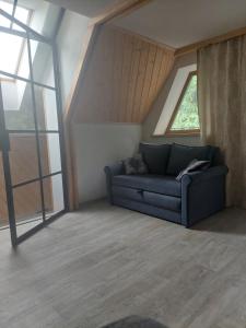 a living room with a couch in front of a window at Na Sopie in Witów