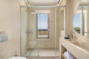 a bathroom with a shower with a glass door at New Beachfront Mesogaia Villa with Heated Pool, Jacuzzi & Playroom, 60m from the beach in Pigianos Kampos