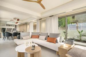a living room with a couch and a table at New Beachfront Mesogaia Villa with Heated Pool, Jacuzzi & Playroom, 60m from the beach in Pigianos Kampos