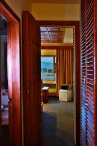 Habitación con puerta que da a una habitación con ventana en Hotel Zeus, en Riobamba
