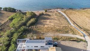 an aerial view of a beach and the ocean at New Beachfront Mesogaia Villa with Heated Pool, Jacuzzi & Playroom, 60m from the beach in Pigianos Kampos +71 photos