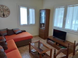 a living room with a couch and a tv at Casa Acantilado Barreiros in Barreiros +15 photos