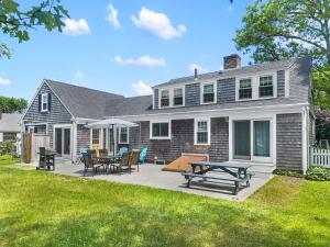 a house with a patio with tables and chairs at 54 Hiawatha Road Harwich Port Cape Cod - Ocean's Favorite in Harwich Port