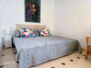 a bedroom with a bed with two pillows and a painting at AGAMARI La Mata Torrevieja sun apartment in Torrevieja