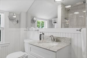a white bathroom with a sink and a toilet at Carlisle House Inn in Nantucket +144 photos