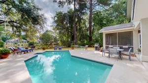 a swimming pool in a yard with a table and chairs at 2 Off Shore in Hilton Head Island