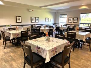 a dining room with tables and chairs with flowers on them at Midland Inn & Suites in Midland