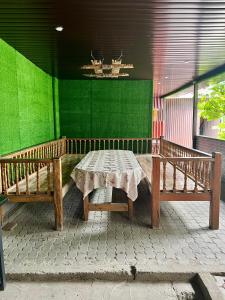 a table and benches on a patio with a green wall at Гостевой дом Сафар in Kapchagay