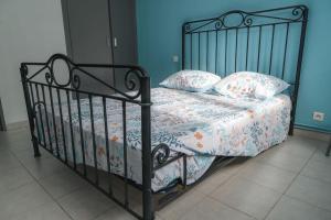 ein schwarzes Bett mit Kissen und einer Decke darauf in der Unterkunft Vacances entre mer et montagne in Alès + 23 Fotos