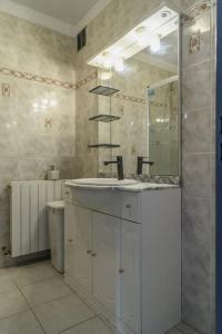 ein Badezimmer mit Waschbecken und Spiegel in der Unterkunft Vacances entre mer et montagne in Alès