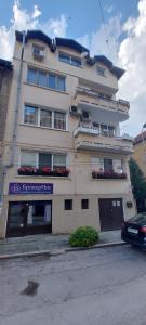 a large white building with flowers in the windows at Downtown Veliko Tarnovo 2 in Veliko Tŭrnovo