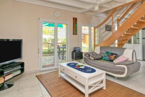 a living room with a couch and a tv at Maison de vacances, 100m plage in Batz-sur-Mer