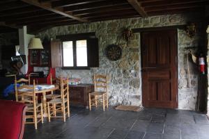 a room with a table and chairs and a wooden door at Casa Maruxela in Borines