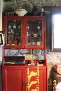 a red cabinet with dishes in it in a kitchen at Casa Maruxela in Borines