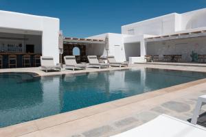 a swimming pool with chairs and a house at KAMEO, Antiparos in Antiparos