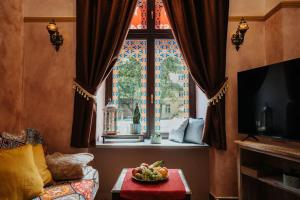 salon z oknem i miską owoców na stole w obiekcie Apartament Shahrazad w Krakowie