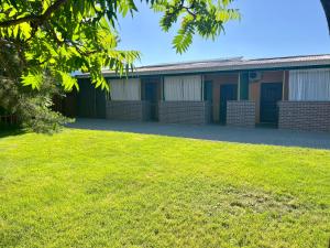 a building with a lawn in front of it at Гостевой дом Сафар in Kapchagay