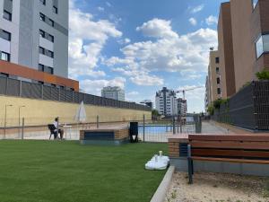 a person sitting on a bench in a park at APARTAMENTO LUXURY in Madrid