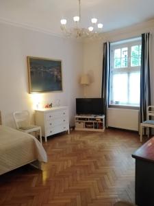 a bedroom with a bed and a television on a wooden floor at Zloty Kąt in Gdańsk