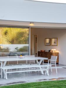 a white dining room with a table and chairs at Precious House in Comporta in Carvalhal +20 photos
