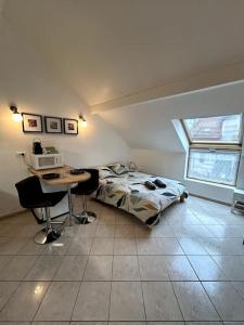 a bedroom with a bed and a desk with a computer at Le Mirande Studio indépendant dans maison in Dijon