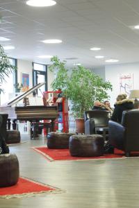 a room with a piano and chairs with tires on the floor at Ethic étapes Val de Loire in Blois