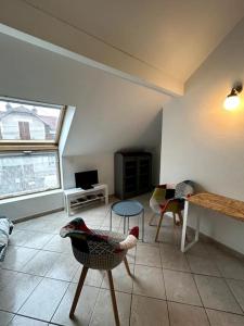 a living room with chairs and a table and a window at Le Mirande Studio indépendant dans maison in Dijon +13 photos