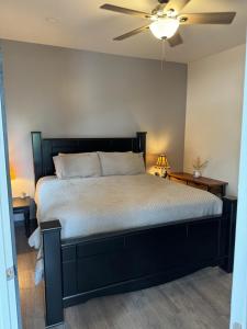 a bedroom with a black bed with a ceiling fan at Sugar on The Sugar River in Albany