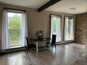 a dining room with a table and chairs and windows at Sugar on The Sugar River in Albany