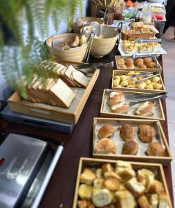 uma linha de buffet com diferentes tipos de pão e pastelaria em Hotel do Mar Tambaú em João Pessoa