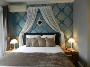 um quarto com uma cama grande e papel de parede azul em Juliette's em Ypres