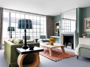 a living room with a couch and a fireplace at The Soho Hotel, Firmdale Hotels in London