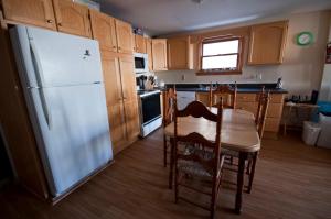 a kitchen with a table and chairs and a refrigerator at Two bedrooms and large office close to Halifax Citadel in Halifax