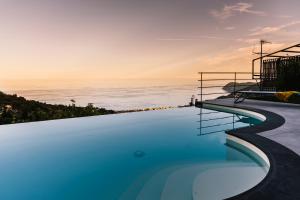 a swimming pool with the ocean in the background at BLUVARI' Charming House in Alassio