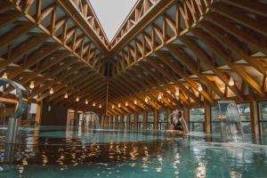 a woman sitting in the water in a swimming pool at Villa Aimée Luxury Apartments with Heated Pool in Vals-les-Bains