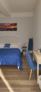 a bedroom with a blue bed and a desk and a desk at Casa Alysa Agriturismo in Tavullia