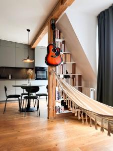 a guitar hanging from a staircase in a living room at Apartament Za Groblą in Poznań