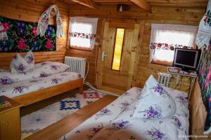 a bedroom with two beds in a wooden cabin at Cabana Victor in Sighetu Marmaţiei