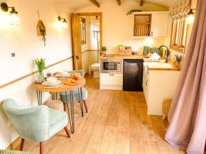a small kitchen with a table in a tiny kitchen at Lintmill Lodges - Thistle Shepherds Hut in Sorn