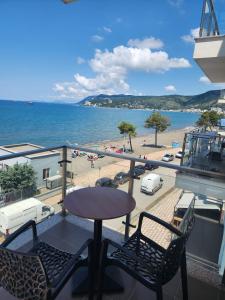 een balkon met een tafel en stoelen en uitzicht op het strand bij Home holiday kozmai in Shëngjin