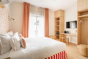 a bedroom with a large white bed and a desk at Villa Camille Hotel & Spa in Banyuls-sur-Mer