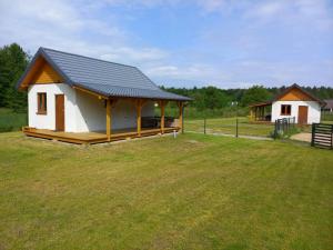 a small cabin with a roof on a grass field at Choczewski Zakątek in Choczewo