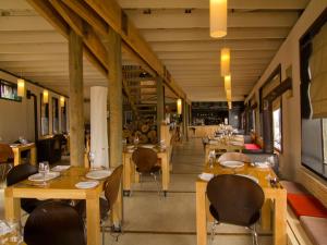 a restaurant with wooden tables and chairs and a hallway at NOI Indigo Patagonia in Puerto Natales