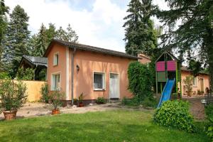 a house with a blue slide in front of it at Ferienhäuschen am See in Bestensee