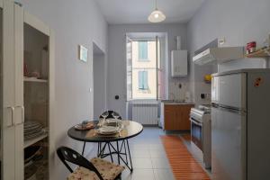 una cucina con tavolo e tavolino con sedie di Bilocale Mazzini a Ventimiglia