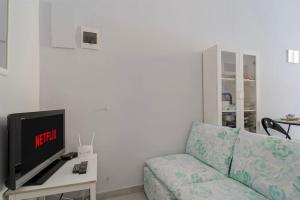 un soggiorno con un divano e una TV di Bilocale Mazzini a Ventimiglia