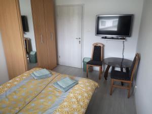a small room with a bed and a table and a tv at Sobe Zeleni raj in Podnart