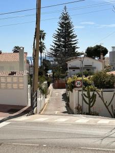 an empty street with a house and a speed limit sign at Beach Apartment, Torre Benagalbón in Torre de Benagalbón