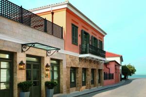 a row of buildings on a street next to the ocean at The Captain's House Boutique Hotel in Preveza