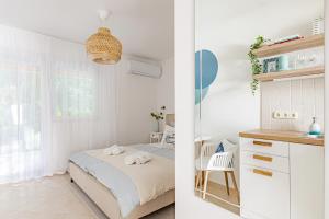 Habitación blanca con cama y escritorio en Blue Beach Apartman, en Zamárdi